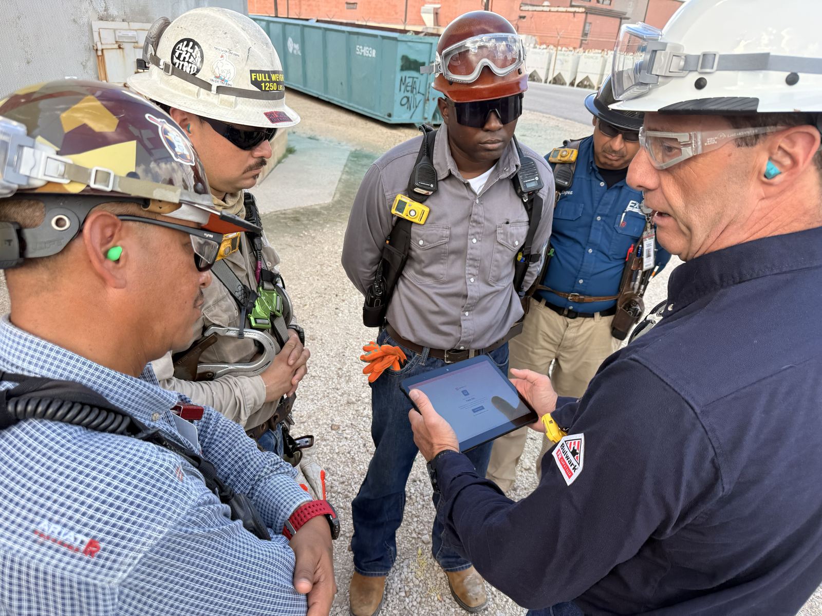 A supervisor showing the digitized JSA on a tablet to the crew on site